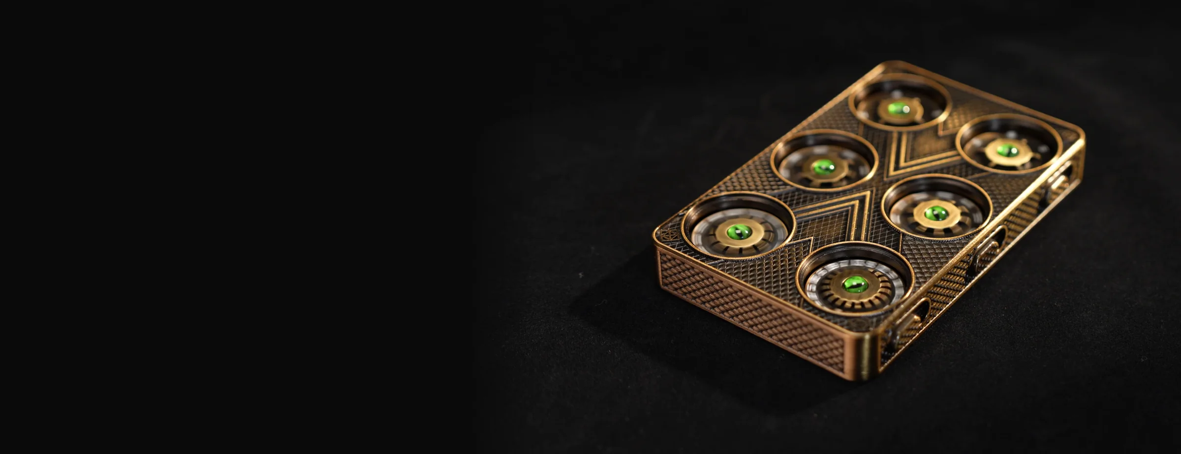 Dragon's Verdict mechanical dice roller in bronze, seen from a three-quarter angle with six dials, each with a green dragon-eye center